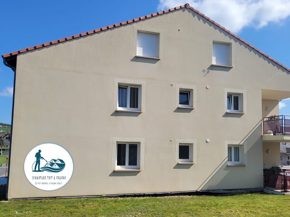 Pignon d'un immeuble à la façade crème refaite, sous un ciel bleu